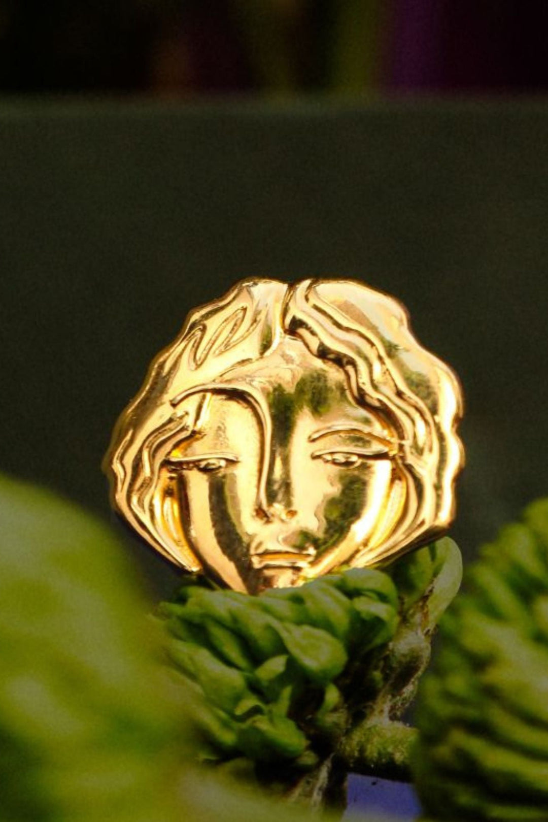 A gold-plated ring with a design that resembles a woman's face, Bilitis