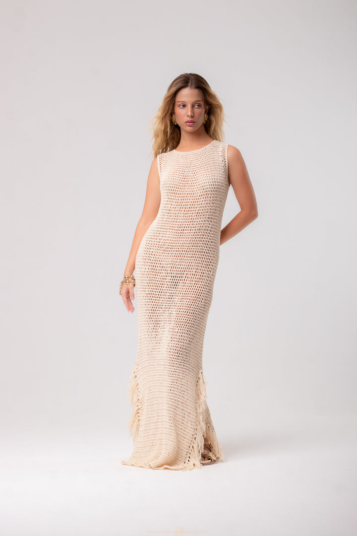 an off-white, long, sleeveless crochet dress.