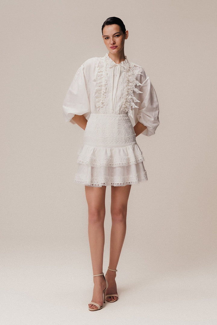 An off-white, long sleeve linen shirt with Guipir lace detailing, a crew collar, and front button closure.