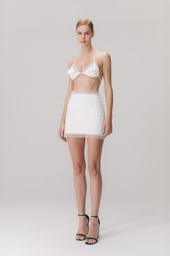A short skirt with mandala guipure appliqués in off white color, featuring a high-waisted design and a side closure with an invisible zipper.