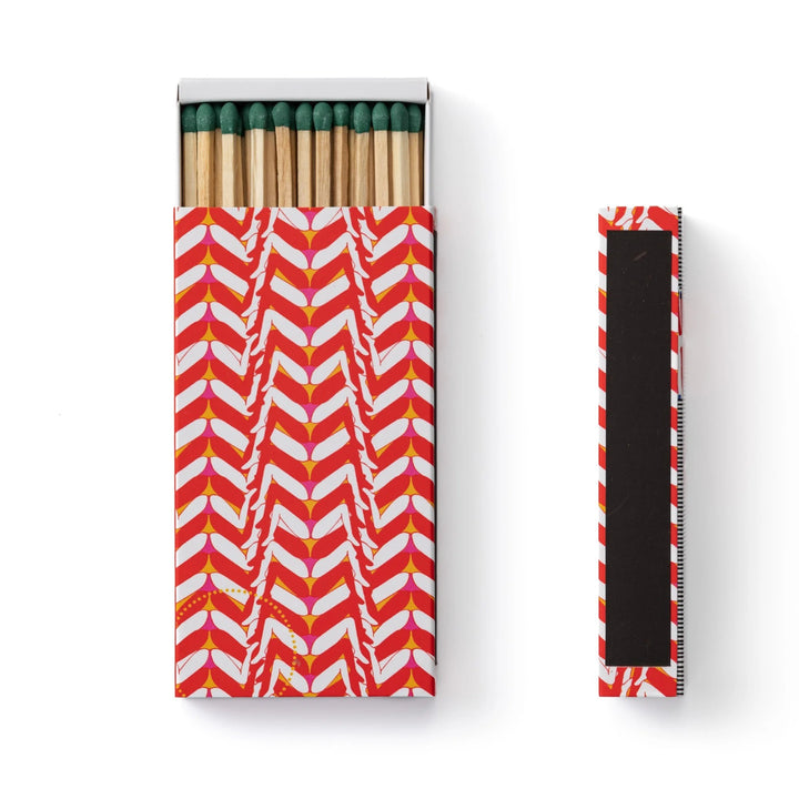 A pack of safety matches with an exclusive Gisela Pecego illustration, displayed in a slim matte box with a geometric pattern.