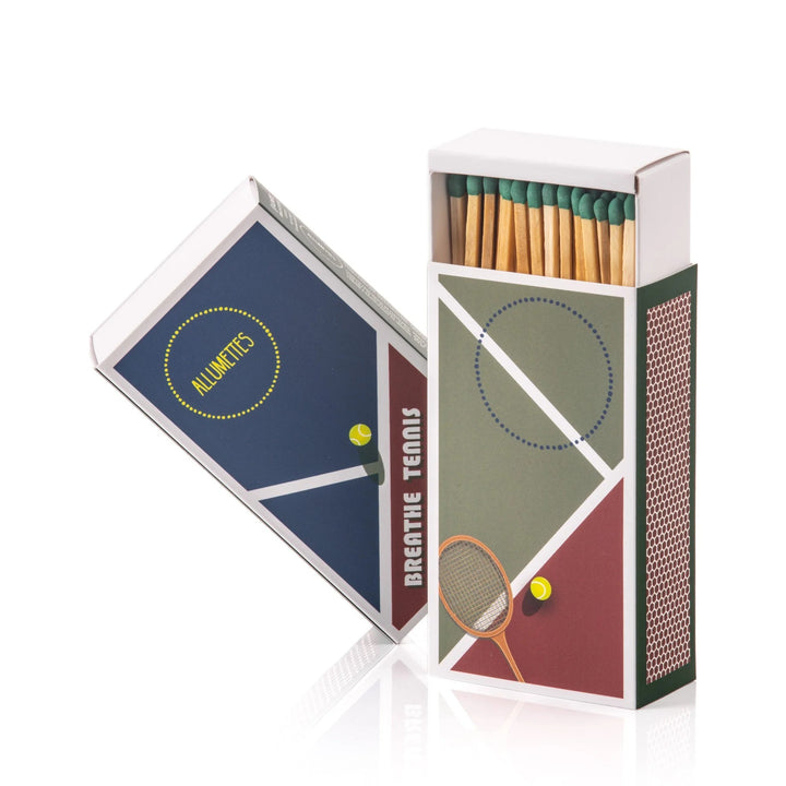 A rectangular matchbox with a matte finish featuring tennis-themed graphics, including a racket and a ball, with a color block design in blue, green, and red.